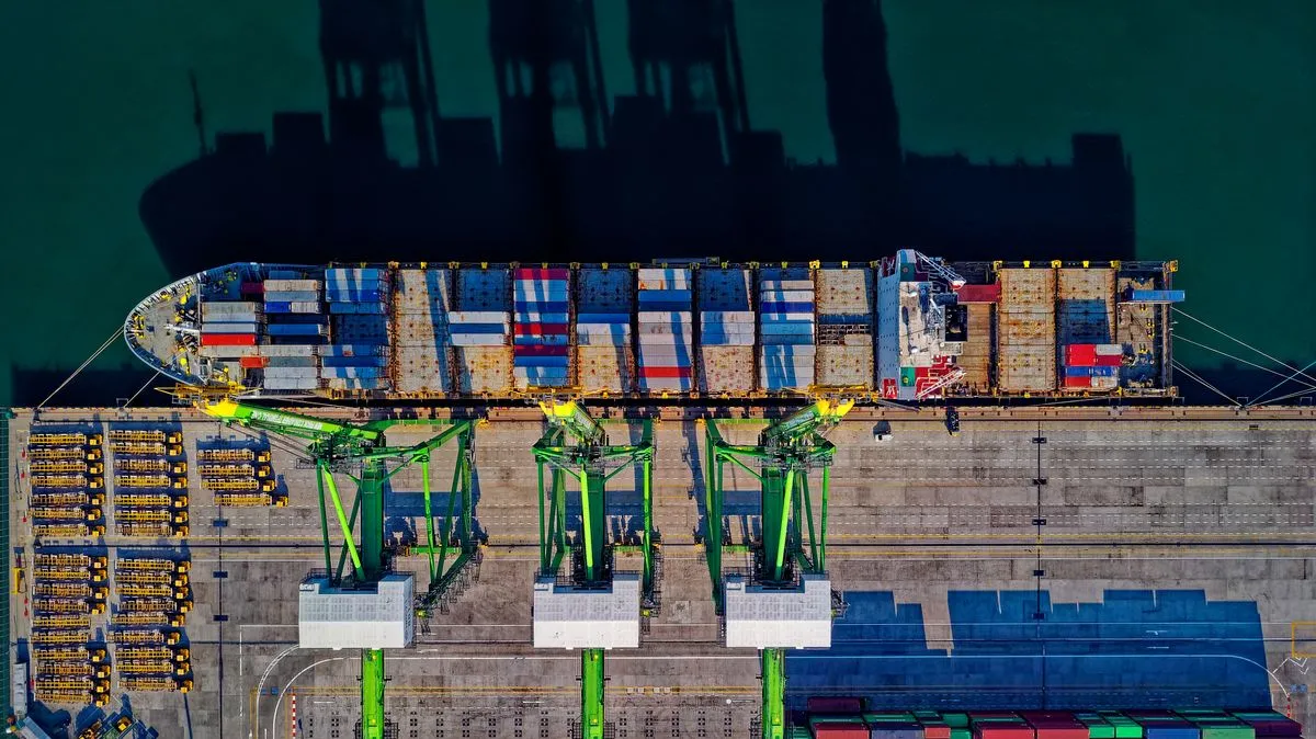 Container impilati e caricati al porto per il commercio internazionale